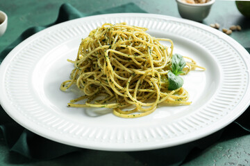 Plate with tasty pesto pasta on table
