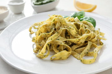 Plate with tasty pesto pasta on table