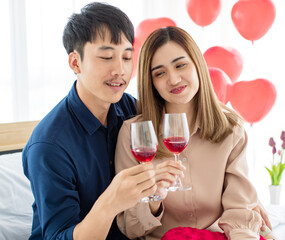 Happy Asian couple proposing toast during date