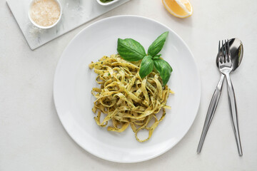 Plate with tasty pesto pasta on table