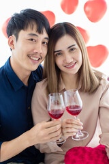 Happy Asian couple proposing toast during date