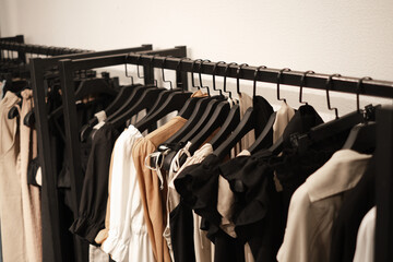 fashionable clothes made from natural fabrics on hangers in the store. new minimal collection of clothes in the boutique.