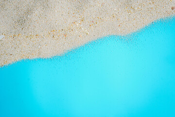 Sea beach sand texture on blue background with copy space. Summer background concept for products display. 