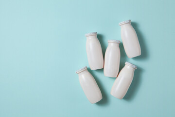 Bottles with probiotics and prebiotics dairy drink on light blue background.