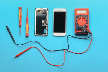 Disassembled mobile phone with technician tools on color background