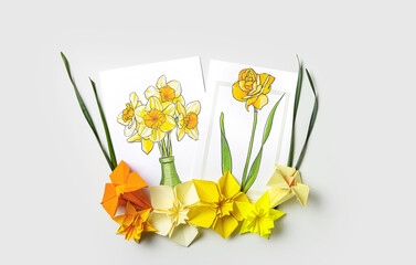 Origami narcissus flowers and greeting cards on white background