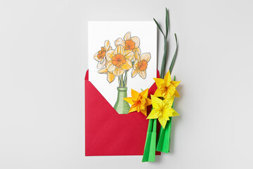 Origami narcissus flowers and envelope with greeting card on white background