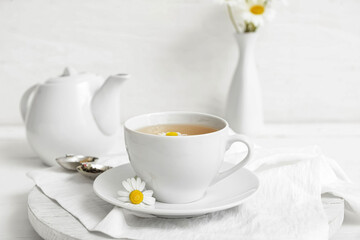 Composition with cup of floral tea on light background