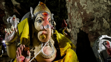 A statue of the Hindu god Ganesha with an elephant's head. This god brings good luck in business. The altar near the sacred tree.