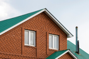 Red brick house with green roof. Traditional european cultures architecture.