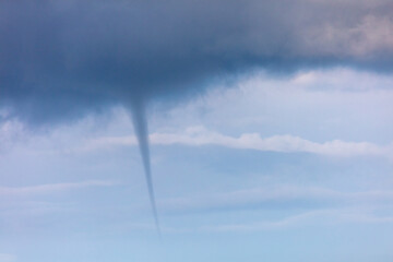 A tornado forms in the clouds.