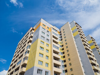 Fototapeta na wymiar Modern beautiful new buildings. Colored wall on the background of blue sky.