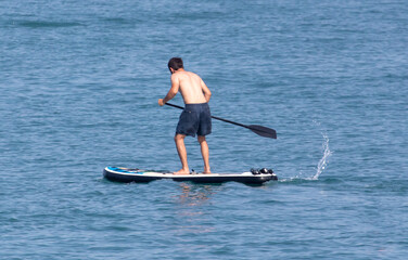 Fototapeta na wymiar A man floats on a board