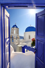 Santorini view with churches against blue door in Oia village, Greece