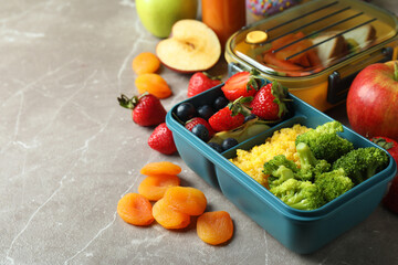 Lunch boxes with tasty food on gray textured table