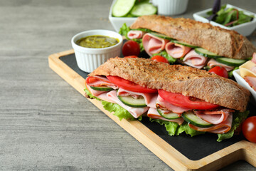 Concept of tasty eating with ciabatta sandwiches on gray textured table