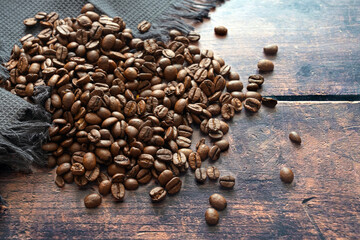 Roasted coffee beans on rustic wood for a fragrant and aromatic hot drink with and without...