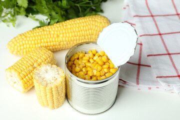 Raw corn and canned corn on white table