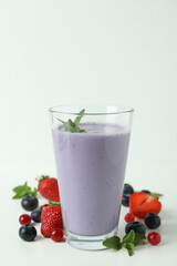 Glass of smoothie and ingredients on white background