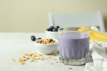 Concept of tasty breakfast with blueberry smoothie on white textured table