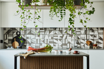 Stylish kitchen interior design with dining space. Workspace with kitchen accessories on the back ground. Creative walls with woode pannels. Minimalistic style an plant love concept.