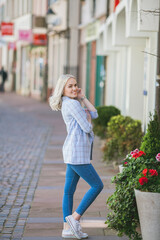 Portrait of a beautiful young woman in a European city. Makes purchases. Tourism. Summer.