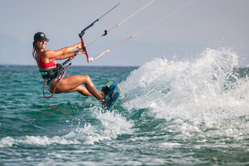 Mujer atractiva con gorra practicando kitesurf en la Playa de Los Lances, Tarifa, Cádiz,...
