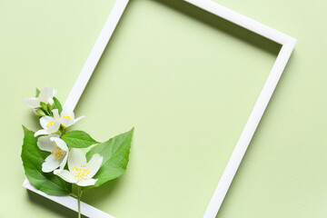 Empty picture frame and beautiful jasmine flowers on color background, closeup