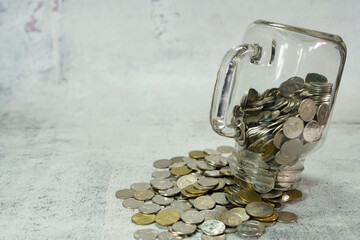 A glass jar with coins upside down to the floor.