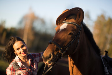 Obraz premium Young farmer woman playing with her horse in a sunny day inside corral ranch - Concept about love between people and animals