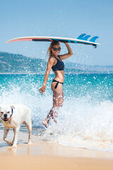 Sexy blonde surfer girl with her dog having fun on the beach, Punta Paloma, Tarifa, Cádiz, Andalusia, Spain