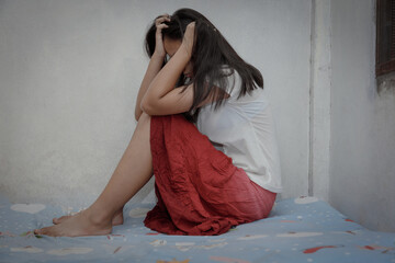 Sad young girl sitting on bed room,domestic violence concept