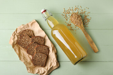 Bottle of fresh kvass on color wooden background