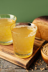 Glasses of fresh kvass on wooden background