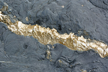 Black volcanic stone with golden streak
