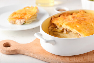 Baking dish with tasty potato casserole on light background, closeup