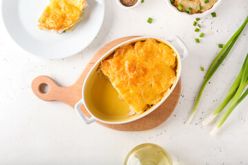 Baking dish with tasty potato casserole on light background
