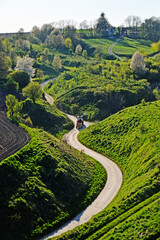 A winding road , landscape and a moving tractor
