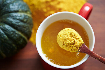 Mini sweet pumpkin with yellow powder on spoon