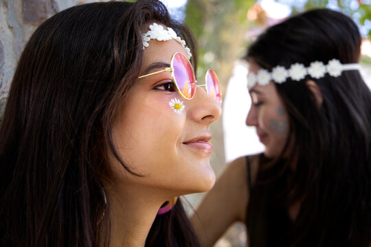 young woman smiling with hippie style in the foreground with another girl in the background