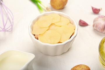 Preparing of tasty potato casserole in ramekin on light background, closeup