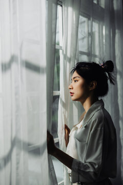 alone thoughtful sadness Asian woman is sad at the window. feeling remorse, break up in relations, divorce and jealousy concept.