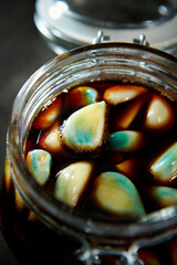 Garlic marinated in soy sauce in a glass container