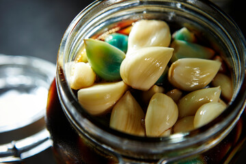 Garlic marinated in soy sauce in a glass container