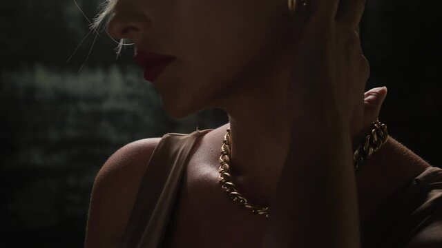 Sexy blonde with a gold chain and luxurious earrings.