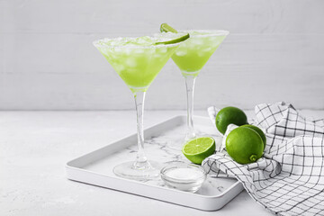 Tray with glasses of tasty daiquiri cocktail on light background