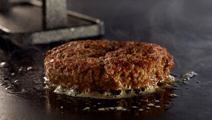 Sizzling juicy thick ground beef burger on a grill