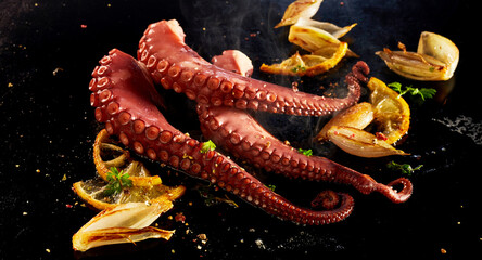 Portion of delicious octopus tentacles grilling with fresh onion