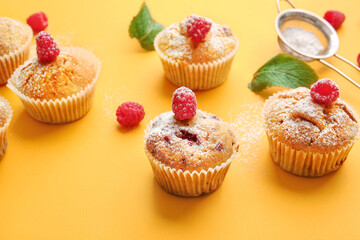 Tasty raspberry muffins on color background, closeup
