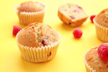 Tasty raspberry muffins on color background, closeup